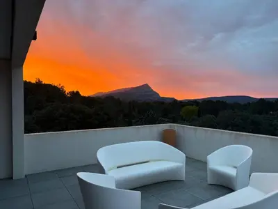 a balcony with a view of a mountain at sunset at Belvédère Sainte Victoire in Saint-Marc-Jaumegarde