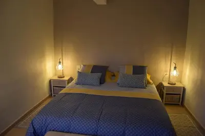 a bedroom with a blue bed with two night stands at Moulin des Gypses Gîte Les Pampres, Ventoux in Mormoiron