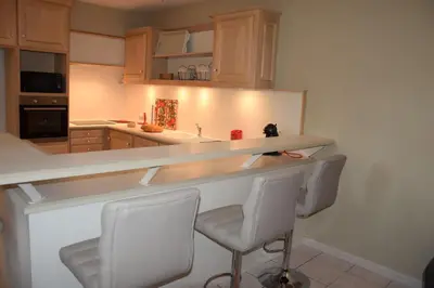 a kitchen with a counter and chairs in it at Moulin des Gypses Gîte Les Pampres, Ventoux in Mormoiron