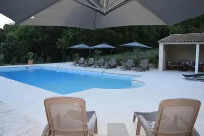 a swimming pool with chairs and an umbrella at Moulin des Gypses Gîte l'Oliveraie, Ventoux in Mormoiron