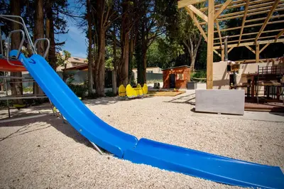 a playground with a blue slide in a park at Appartement charmant près du centre d'Avignon, 60m², piscine in Avignon