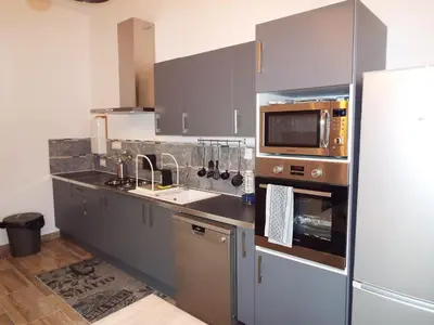 a kitchen with gray cabinets and a sink and a microwave at Appartement charmant près du centre d'Avignon, 60m², piscine in Avignon