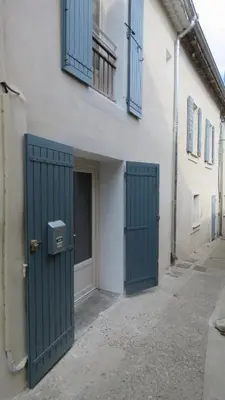 a building with two green doors on the side of it at Cycle , Cook and Relax in Caromb