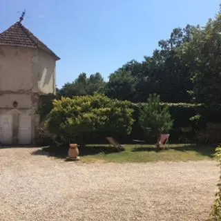 a yard with two chairs and a building and trees at Mas Provencal Monteux 84170 in Althen-des-Paluds