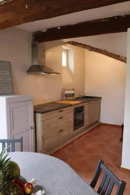 a kitchen with a table and a stove top oven at Mas Provencal Monteux 84170 in Althen-des-Paluds