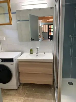 a bathroom with a sink and a washing machine at Maison du vallon de Galeye in La Roque-sur-Pernes