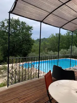 a deck with a view of a swimming pool at Maison du vallon de Galeye in La Roque-sur-Pernes