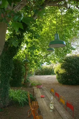 a wooden table with chairs and a bottle of wine at Le Cabanon Provençal Traditionnel Jardin Barbecue & Cheminée in Saumane-de-Vaucluse