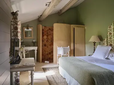 a bedroom with a bed and a bathroom with a sink at Villa Syrah, La Bastide de Marie, Villa avec services in Ménerbes