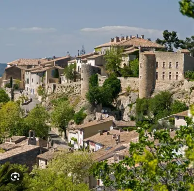 a village on top of a hill with buildings at La Cour Intérieure Ménerbes in Ménerbes