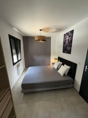 a bedroom with a large bed in a room at Appartement neuf centre du village in Le Puy-Sainte-Réparade