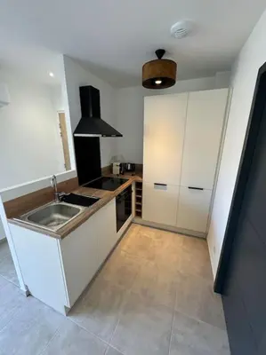 a kitchen with a sink and a counter top at Appartement neuf centre du village in Le Puy-Sainte-Réparade