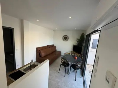 a living room with a couch and a table at Appartement neuf centre du village in Le Puy-Sainte-Réparade