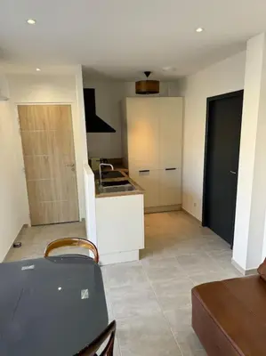 a kitchen with a table and a counter top at Appartement neuf centre du village in Le Puy-Sainte-Réparade