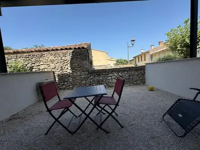 two chairs and a table on a patio at Appartement neuf centre du village in Le Puy-Sainte-Réparade