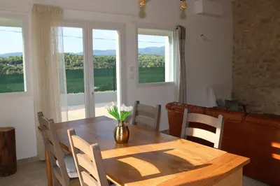 a dining room table with a vase of flowers on it at Les Vignes du Luberon in Saignon