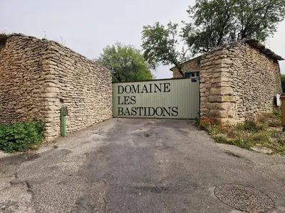 a sign that says doolinilles less bastions on a gate at Le Bastidon des Mésanges in Gordes