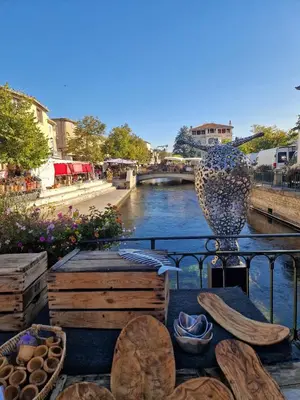 a vase sitting on a table next to a river at Le Bastidon des Mésanges in Gordes