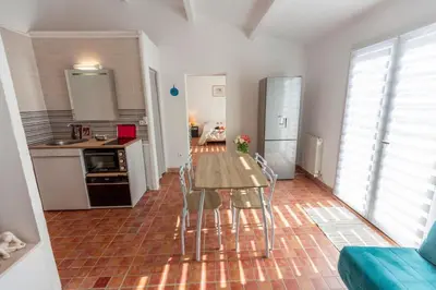a kitchen with a table and chairs in a room at Joli Studio 36m2 tout confort in Châteauneuf-de-Gadagne