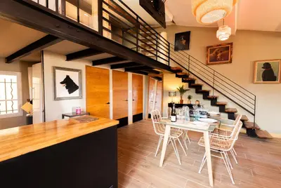 a room with a table and chairs and a staircase at Loft COSY et luxueux, HYPER-CENTRE in Aix-en-Provence