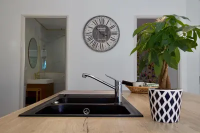 a sink in a kitchen with a clock on the wall at Villa Luberon 3ch piscine jardin parking in Saignon