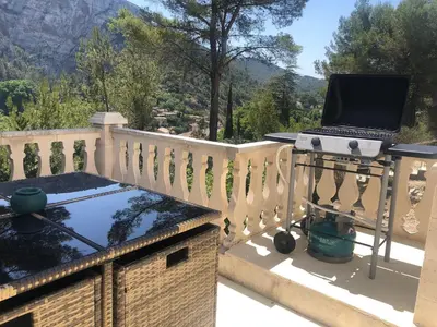 a grill on a balcony with a laptop on a table at B&B Villa Chante Coucou in Fontaine-de-Vaucluse