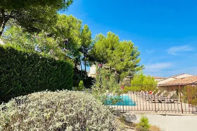 a yard with a swimming pool and some trees at Maison haut de gamme dans le golf de pont royal in Mallemort