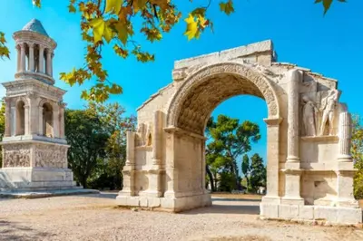 an arch in a park with a tower at Mazet Rigodon Alpilles in Eygalières