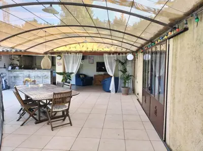 a patio with a table and chairs under a roof at le 1387 l'étape en Provence in Plan-dʼOrgon