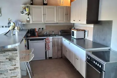 a kitchen with white cabinets and stainless steel appliances at le 1387 l'étape en Provence in Plan-dʼOrgon