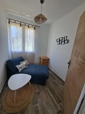 a living room with a blue couch and a table at Nel Home in Mazan