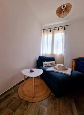 a living room with a blue couch and a table at Nel Home in Mazan