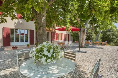 a table and chairs with flowers on top of it at Le Bastidon, Aix en Pce proche centre, climatisé, 4 chambres in Aix-en-Provence