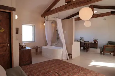 a large bathroom with a tub and a bedroom at Casa Pauseto in Bonnieux