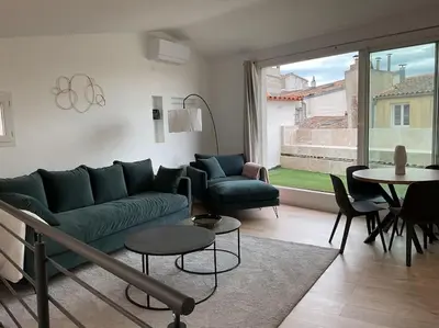 a living room with a green couch and a table at Duplex rénové comme Neuf à Aix-en-Provence in Aix-en-Provence