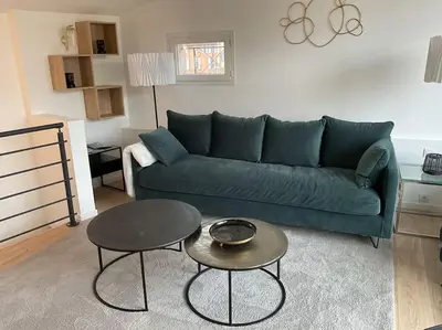 a living room with a green couch and a table at Duplex rénové comme Neuf à Aix-en-Provence in Aix-en-Provence
