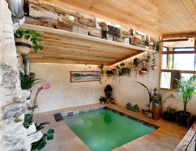 an indoor pool in a house with plants at Ecolieu Silenciane in Simiane-la-Rotonde