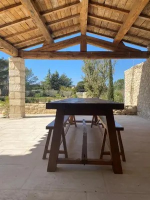 a picnic table under a wooden roof at Mas Au pays des Alpilles in Eygalières