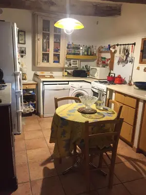 a kitchen with a table with a table cloth on it at Maison de village provençale in Monieux
