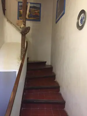 a staircase in a house with a clock on the wall at Maison de village provençale in Monieux