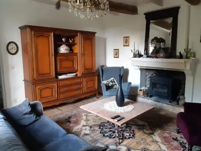 a living room with a blue couch and a fireplace at Maison de village provençale in Monieux