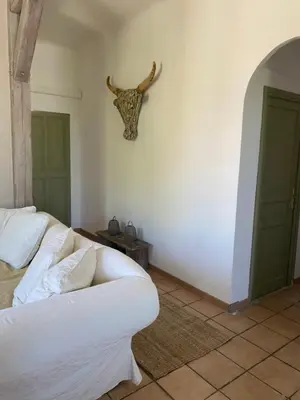 a living room with a white couch and a deer head on the wall at Limasola - Apartment and its rooftop in Les Vignères