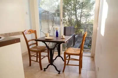 a table and chairs in a kitchen with a window at Le gîte sous les pins in Les Taillades
