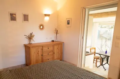 a bedroom with a bed and a wooden dresser at Le gîte sous les pins in Les Taillades