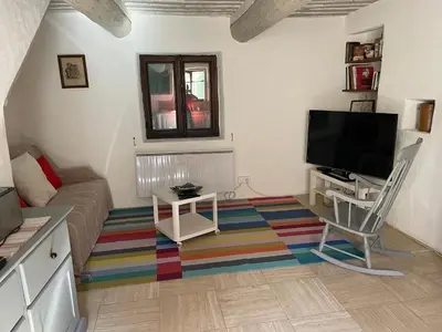 a living room with a couch and a flat screen tv at La Magnanerie in Cabrières-dʼAvignon