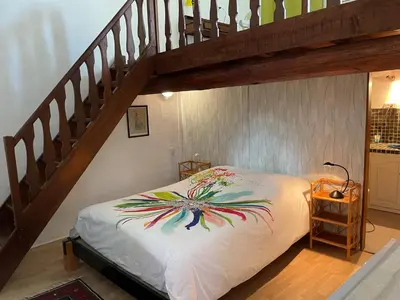 a bedroom with a bed under a staircase at La Magnanerie in Cabrières-dʼAvignon