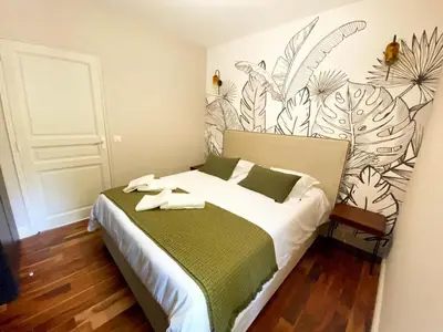 a bedroom with a large bed with a green and white blanket at Domaine Farandole in Eygalières