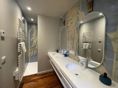 a bathroom with two sinks and a large mirror at Domaine Farandole in Eygalières