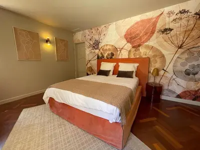 a bedroom with a large bed with a painting on the wall at Domaine Farandole in Eygalières