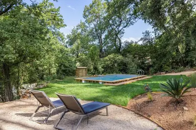 a yard with two chairs and a swimming pool at Villa La Pinède in Aix-en-Provence